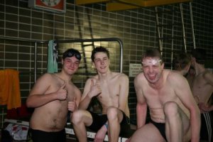 Drei Schwimmer sitzen auf dem Sprungbrett