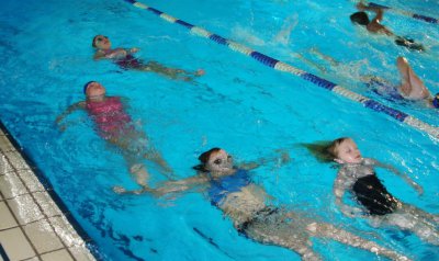 junge Schwimmer auf dem Rücken auf zwei Bahnen